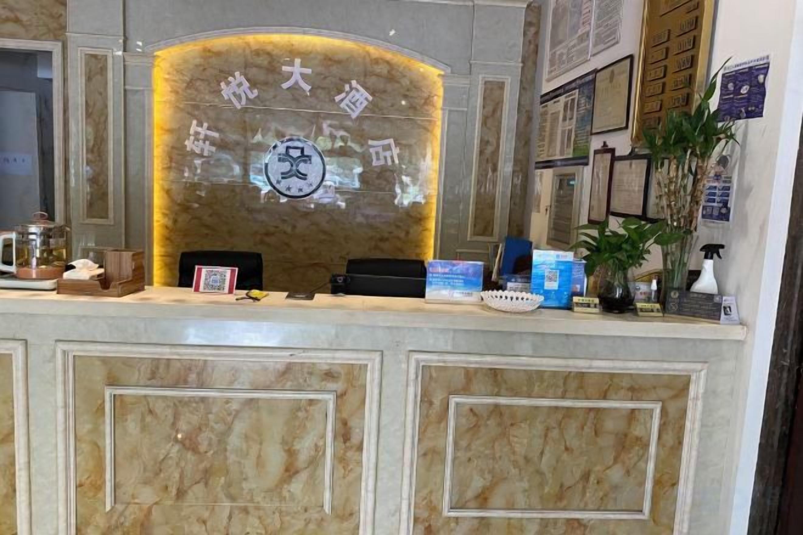 Un mostrador de recepción con acabado de mármol, un logotipo enmarcado y un código QR.