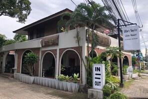 Un edificio de dos plantas con un letrero que dice 'Lila Resort'. Hay un letrero de 'No Entrar' al frente.
