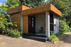 A modern building with a wooden facade, a concrete exterior, and a small outdoor seating area.