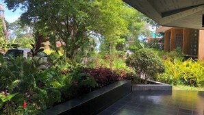 A lush garden area with various plants and a paved walkway. - Likita Resort (Rayong City)