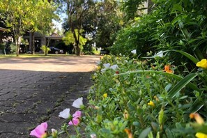 A paved pathway with a garden area on one side. - Likita Resort (Rayong City)