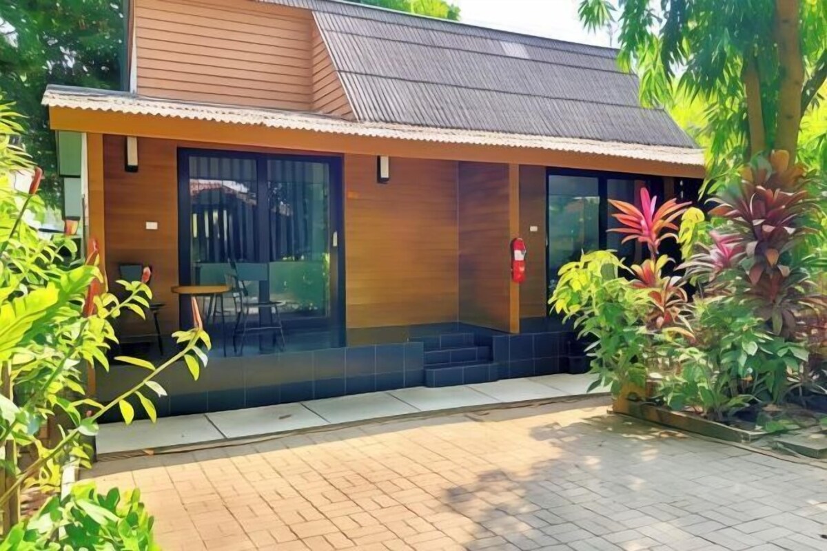 A modern building with a wooden facade, large glass windows, and a tiled entrance area.