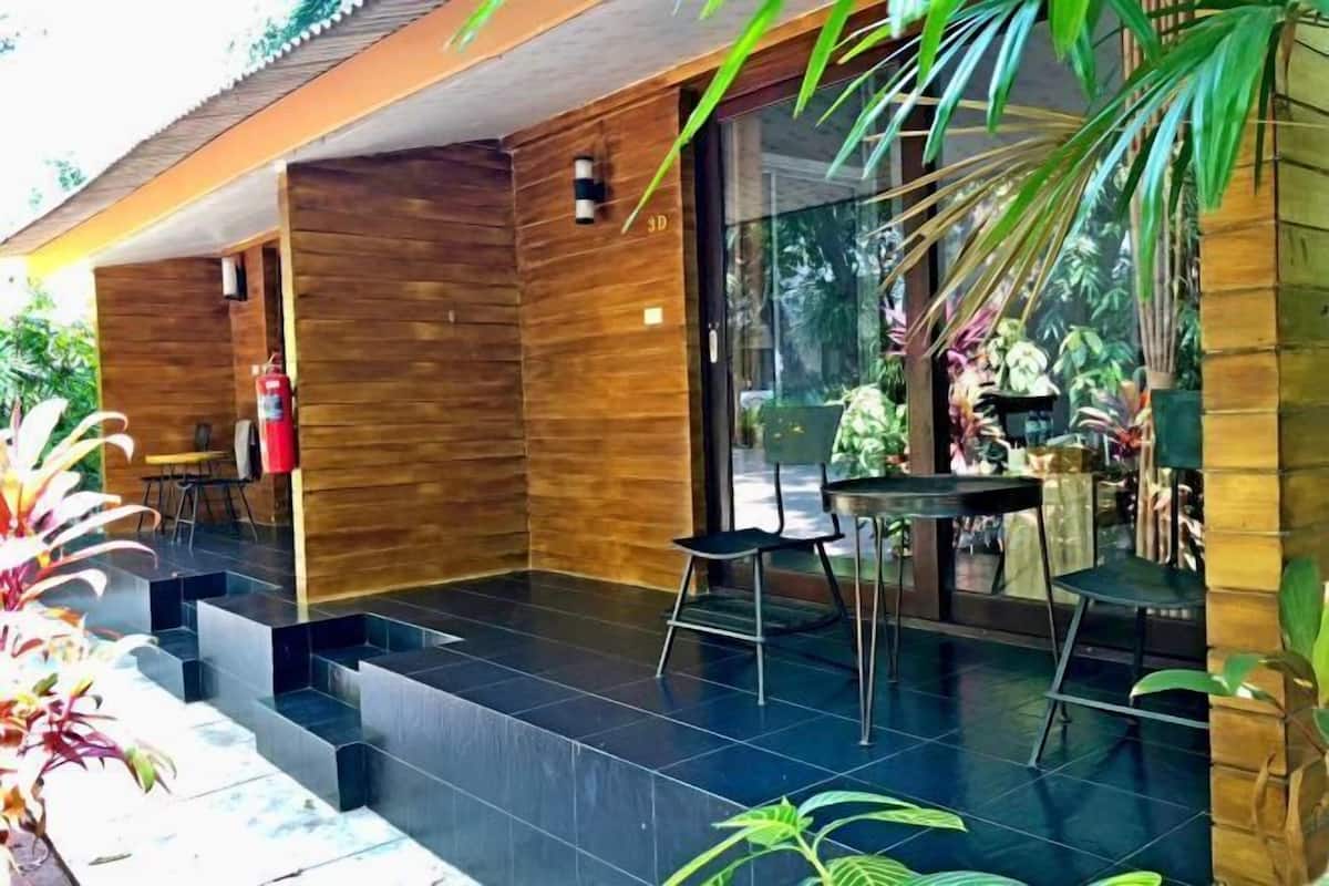 A modern outdoor area with a wooden structure, a fire extinguisher, and a table with chairs.