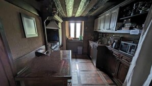 Eine Küche mit Holztisch, Schränken und einem Fenster.