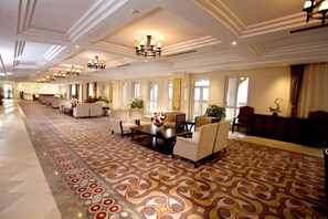A hotel lobby with a patterned carpet, seating areas, and a chandelier. - Zhongcheng Holiday Hotel (Shijiazhuang)