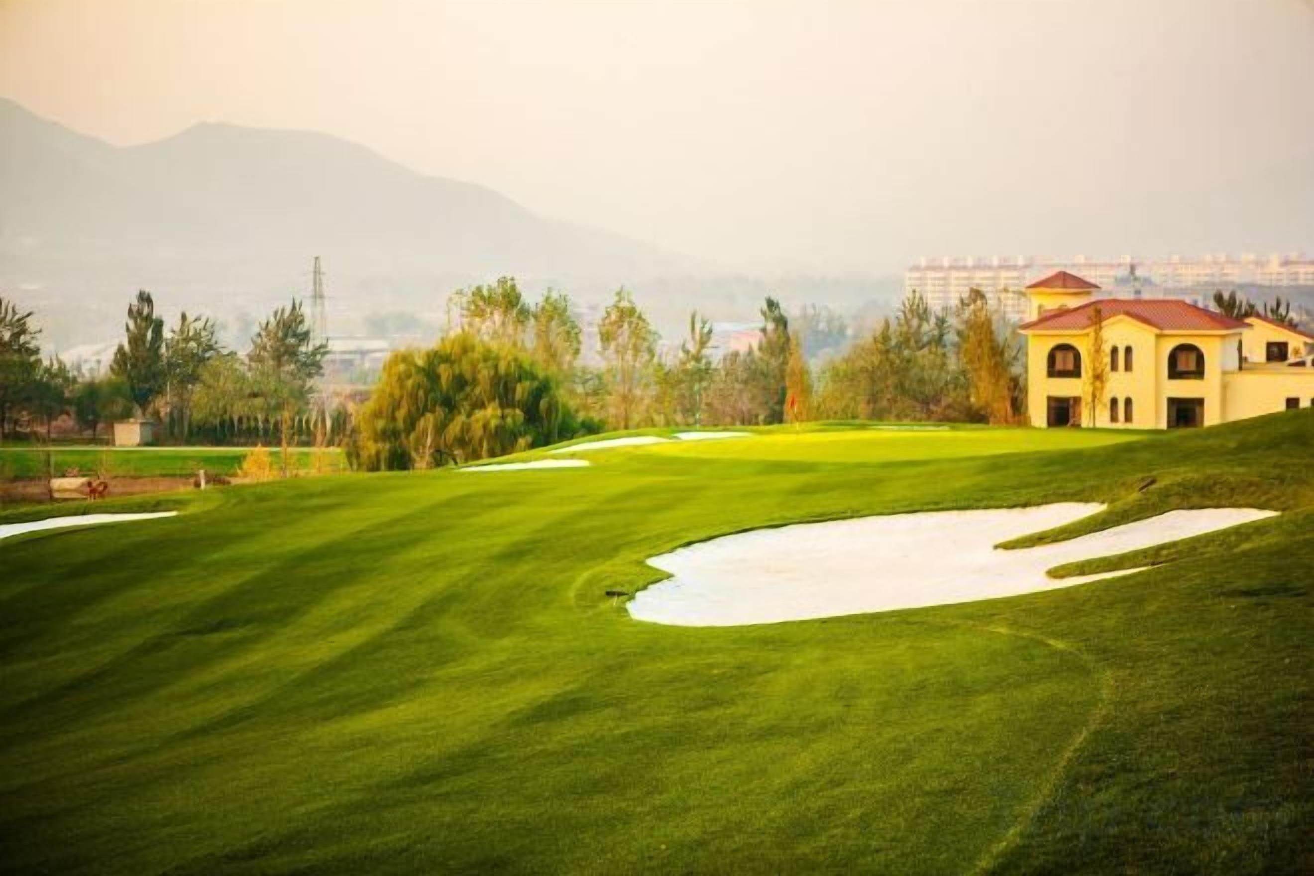 A golf course with a building in the background.