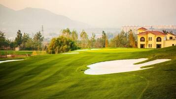A golf course with a building in the background.