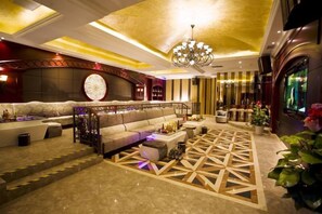 A hotel lobby with a sofa, coffee table, and decorative lighting. - Zhongcheng Holiday Hotel (Shijiazhuang)