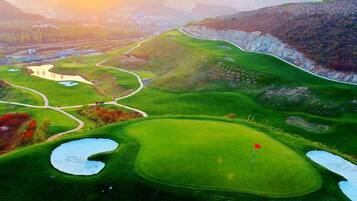 A golf course with multiple holes, water hazards, and a red flag indicating the current hole.