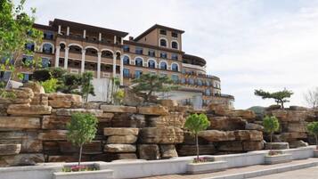 A hotel with a multi-story structure, a courtyard with rock formations, and a large building with a dome.