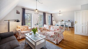 Una sala de estar con sofá, mesa de centro y comedor con mesa y sillas.