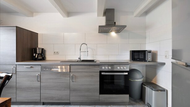 A modern kitchen with stainless steel appliances, a dishwasher, an oven, and a microwave. - Holiday Apartment 'Ferienhaus Op'n Doerp' with Private Terrace, Garden, Wi-Fi & EV Charger (Oesterwurth)