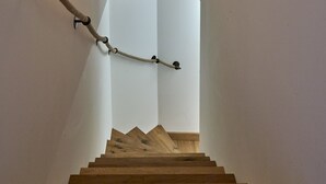 A wooden staircase with a rope handrail, leading to a higher floor. - Apartment 'Steinbock B' with Mountain View, Balcony and Wi-Fi (Klosters-Serneus)