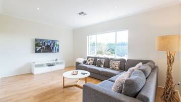 Deluxe House | Living area | 65-inch TV with digital channels, DVD player