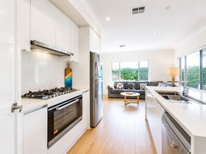 Deluxe huis | Privékeuken | Een koelkast met diepvriezer, een microgolfoven, een oven, een kookplaat