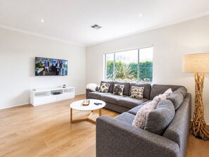 Hus – deluxe | Oppholdsområde | En 65-tommers TV med digitale kanaler samt DVD-spiller