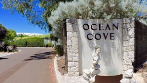 Un panneau indiquant « OCEAN COVE », avec un mur de pierres et un tas de rochers.