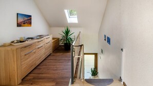 Un interior moderno con un armario de madera, una planta en maceta, un tragaluz y vistas a la ciudad.