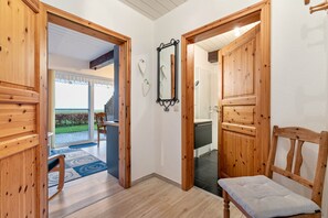 Un interior de madera con un banco, un espejo y una puerta que da a un balcón.