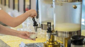 Eine Person bedient eine Kaffeemaschine und füllt ein Glas mit Kaffee.