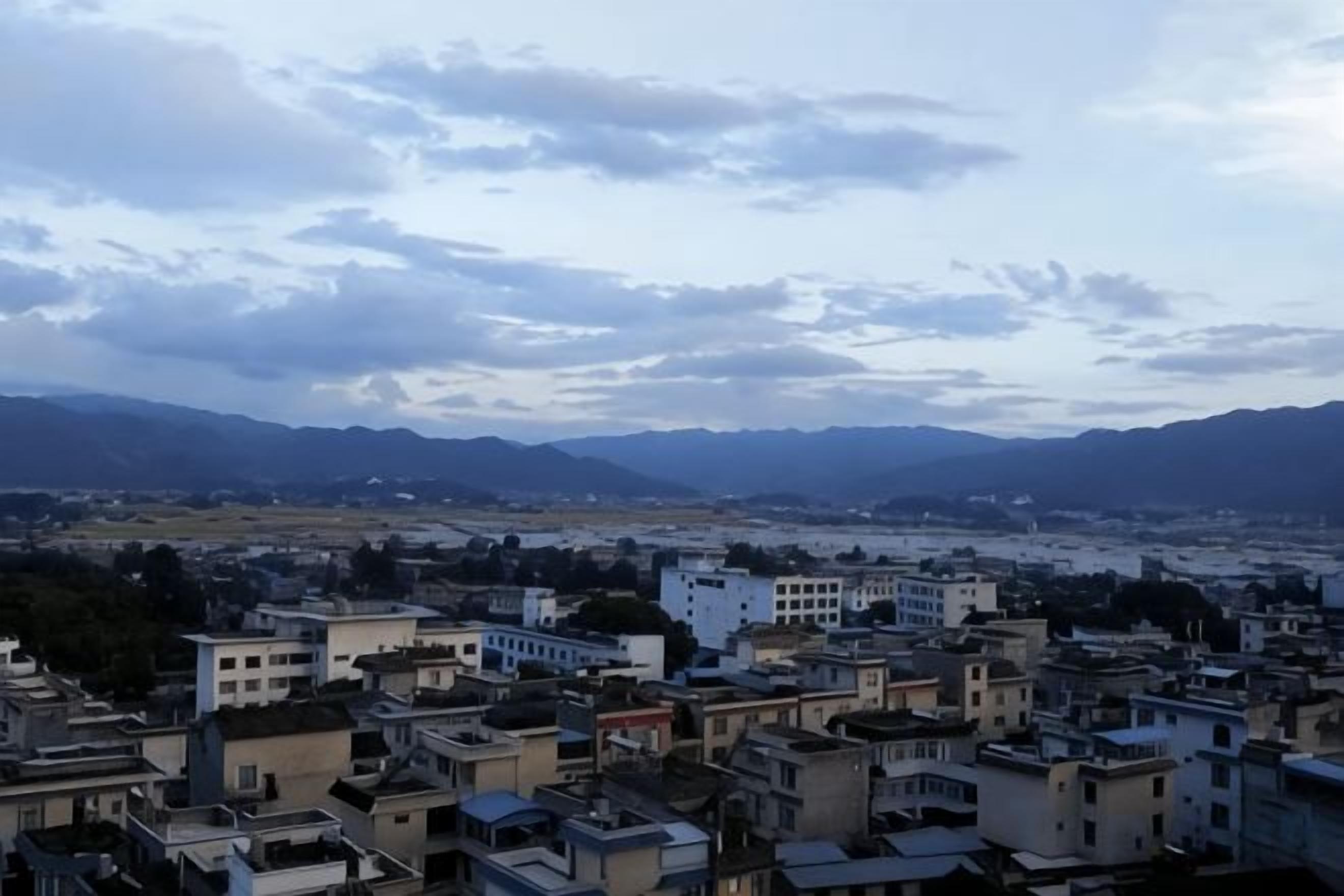 Une vue urbaine avec des bâtiments et des montagnes en arrière-plan.