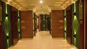 A hotel corridor with mirrored walls and green lighting accents. - Hotel Apollo Grand (Guwahati)