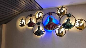 Paret amb aplics decoratius que mostren figures il·luminades amb vestimentes tradicionals.