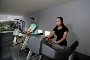 A gym with treadmills and a person using one.