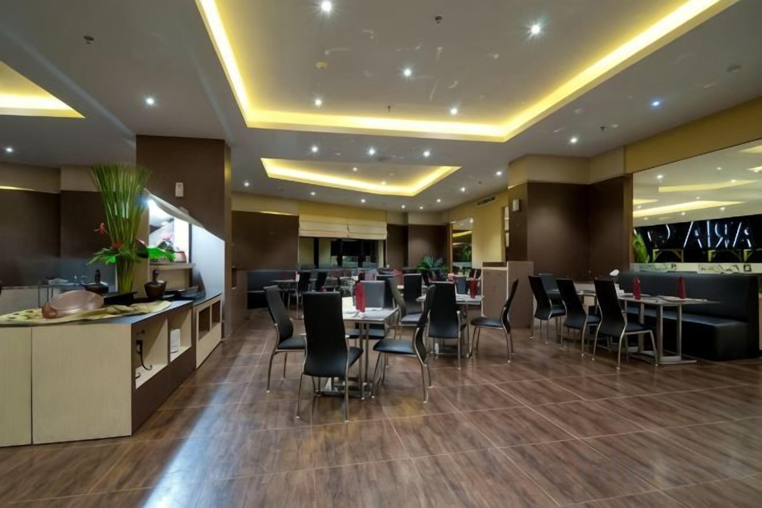A modern restaurant with a central dining area, booths, and a bar area.