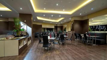 A modern restaurant with a central dining area, booths, and a bar area.