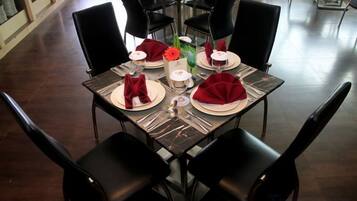 A dining table set with red napkins, plates, and a candle.
