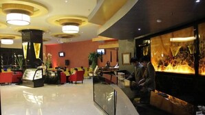 A modern lobby with a reception desk, seating area, and a large decorative wall.