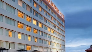 A multi-story hotel with illuminated windows and a clear sky.