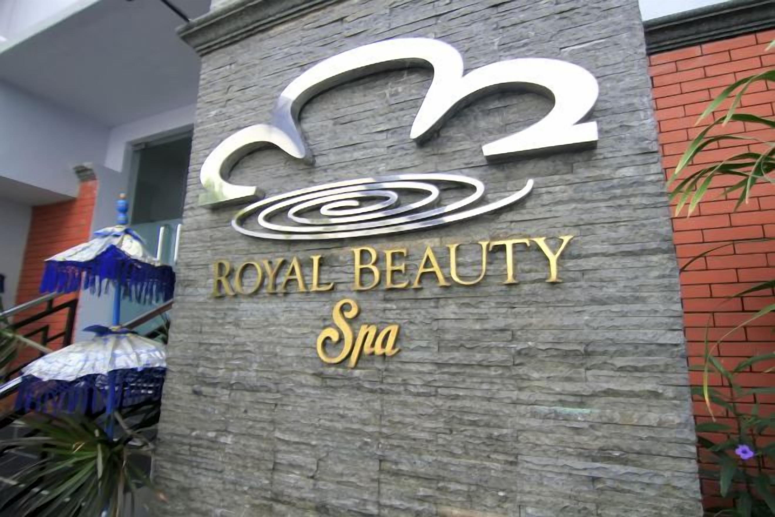 A sign for 'Royal Beauty Spa' with a stylized logo and the name in gold lettering.