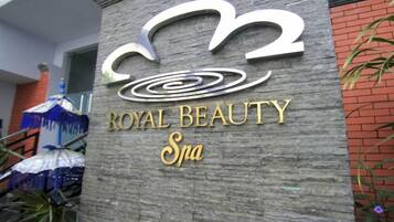 A sign for 'Royal Beauty Spa' with a stylized logo and the name in gold lettering.