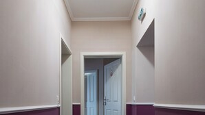Un pasillo con suelo de mármol, paredes color crema y paneles de madera morados.