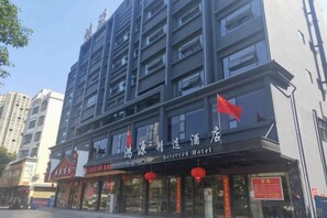 Un hotel de varios pisos con un cartel que indica que es un hotel seleccionado.