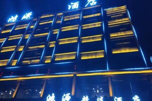 Un edificio con letreros iluminados y varias ventanas.