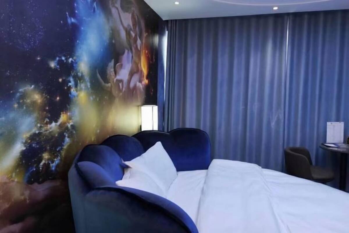 A hotel room with a bed, a desk, and a chair.