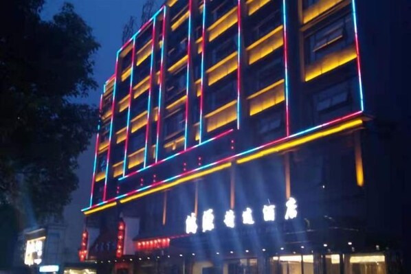 A building with illuminated signage and a series of vertical light strips. - Youxian Hongyuan Selected Hotel (You County)