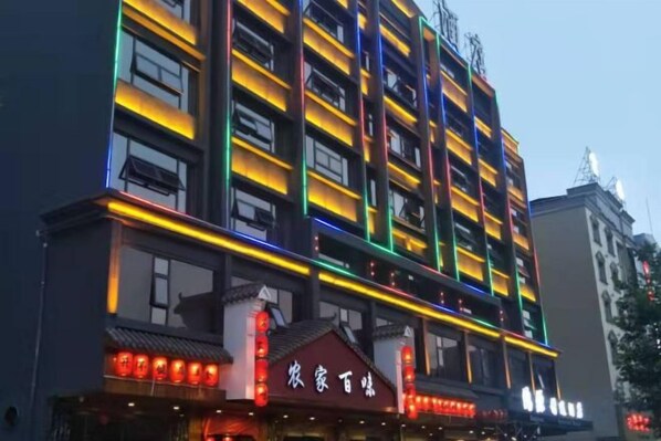 Un immeuble à plusieurs étages, doté d’une enseigne lumineuse et d’un style architectural traditionnel.