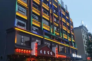 Un edificio de varios pisos con letreros iluminados y un estilo arquitectónico tradicional.