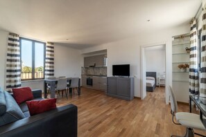 A modern apartment with a living room, dining area, kitchen, and a bedroom.