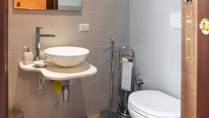 A bathroom with a white sink, a toilet, and a mirror.