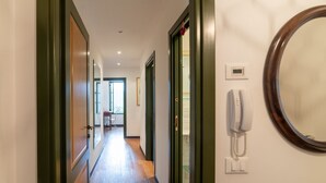 Ein Hotelgang mit Holzboden, einem Telefon und einem Spiegel an der Wand.