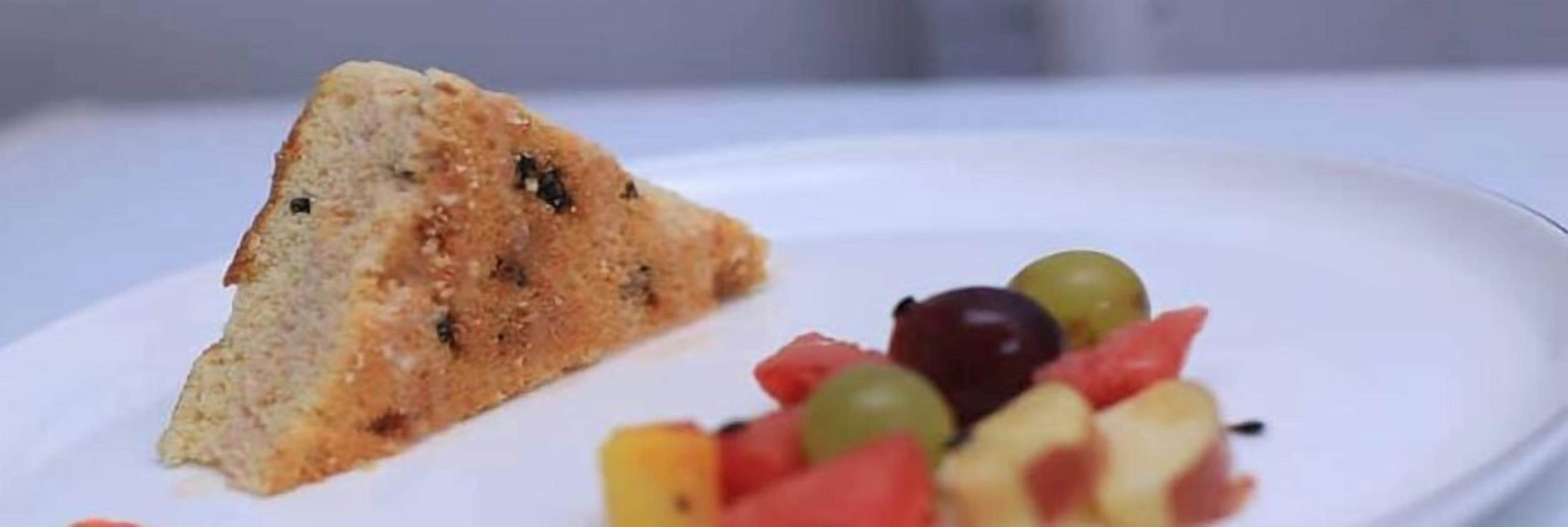 Una porción de pastel con cobertura de fruta sobre un plato.