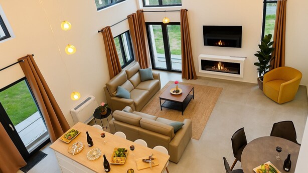 Ein modernes Wohnzimmer mit Sofa, Couchtisch, Essbereich und Kamin.
