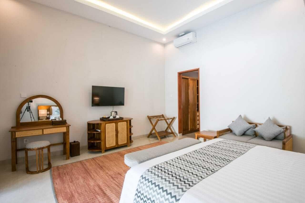 Una camera da letto con un letto, una scrivania, una sedia, una televisione e un armadio.