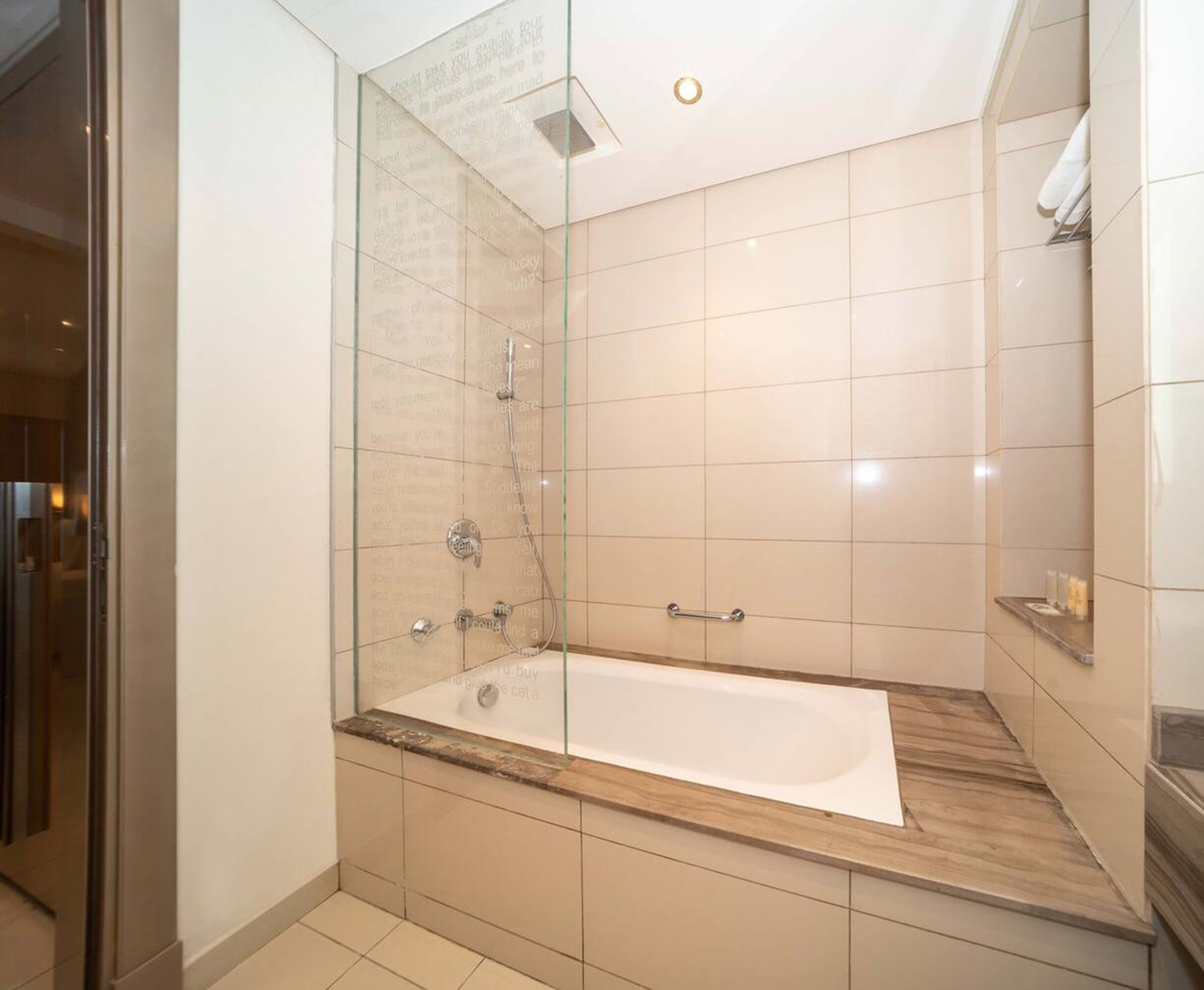 A modern bathroom with a glass-enclosed shower, a freestanding bathtub, and a vanity with a mirror.
