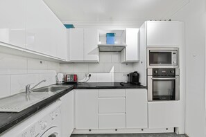 Deluxe-lejlighed - byudsigt | Privat køkken | Køleskab/fryser i fuld størrelse, mikrobølgeovn, ovn, kogeplade